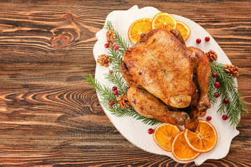 Roasted turkey with orange and fir tree branches on plate