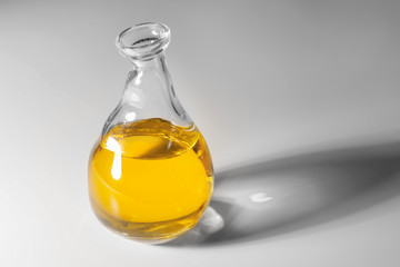 Glass jug with cooking oil on white background
