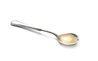 Spoon with cooking oil on white background