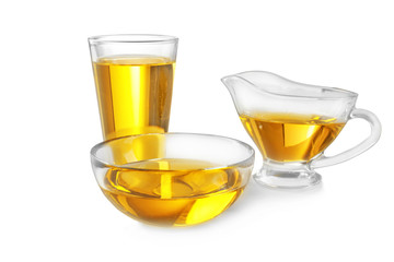 Glassware with cooking oil on white background