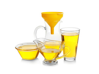Glassware with cooking oil on white background
