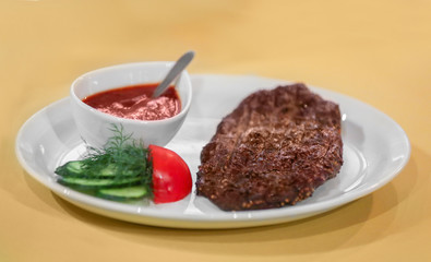 Ostrich steak served with sauce and vegetables on plate