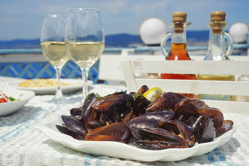 Plate with mussels on table of open air restaurant