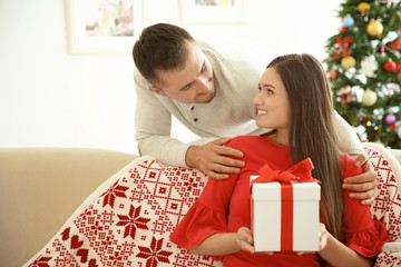 Young man making Christmas surprise for his girlfriend at home