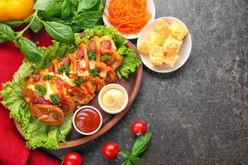 Tasty pastry with sausage on grey background