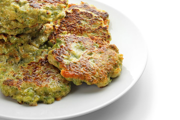 Plate with delicious broccoli pancakes on white background, close up