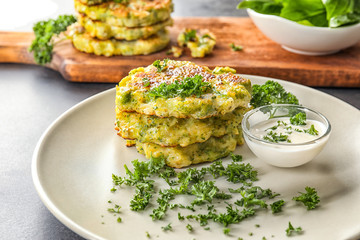Plate with delicious broccoli pancakes on table