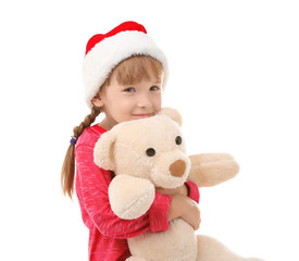 Cute little girl in Santa hat with toy on white background