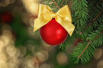 Fototapeta na wymiar Brunch of fir tree with Christmas ball on blurred background
