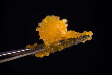 Dannabis concentrate live resin (extracted from medical marijuana) isolated over black - 173321904