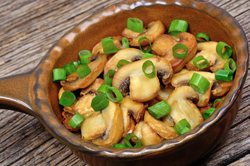 Champignon with green onion in a pan