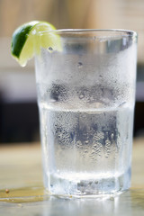 Glass of water with condensation and lime wedge