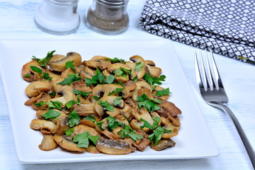 Champignon with parsley in a plate on table