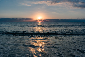 bright sunlight  and blue sky reflecting off the ocean on a calm morning at the beach