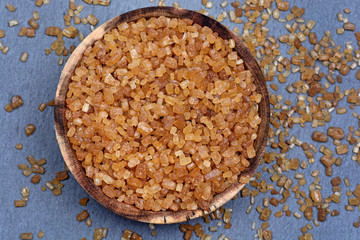 Brown sugar crystals in a bowl on slate