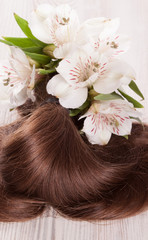 Obraz na płótnie Canvas Shiny hair lock and fresh delicate flowers