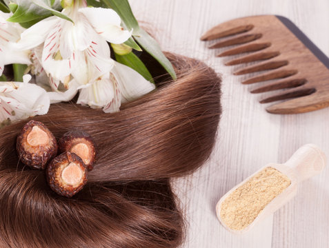 Fragment of healthy shiny woman hair and natural products for haircare