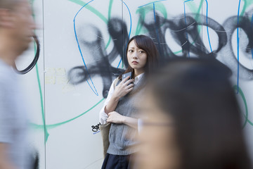 スマホを持ち不安になる暗い女性　渋谷　繁華街