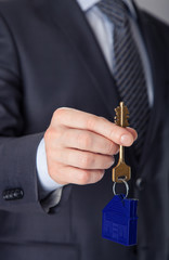 Businessman offering a key from a house to you