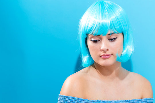 Beautiful woman in a bright blue wig on a blue background