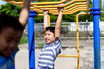 Obraz premium Young asian boy hang out door playground