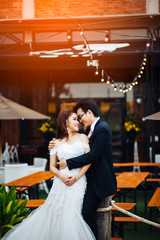 Fototapeta premium The bride and groom sweet on restaurant background. Asian wedding couple on bar restaurant background.