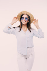 young girl posing in hat and glasses in the whit wall