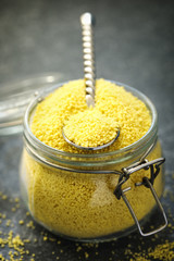 Uncooked couscous in a glass jar, selective focus