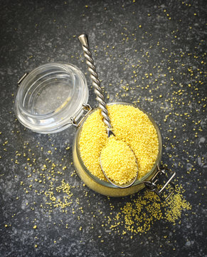 Uncooked couscous in a glass jar, selective focus