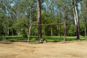 Porter&iacute;a de troncos en cancha r&uacute;stica de f&uacute;tbol.
