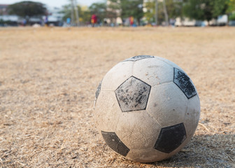 Fototapeta na wymiar Old football on dried grass