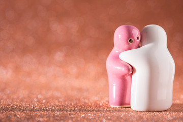 Hugging White and Pink Ceramic Doll on Abstract Blurred Defocused Background.