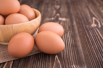 Fresh Eggs in bowl on brown wooden board