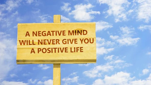 A negative mind will never give you a positive life. Words on a wooden sign against time lapse clouds in the blue sky. 