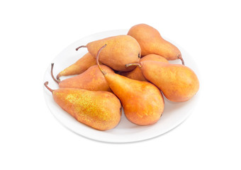 Several Bosc pears on a white dish