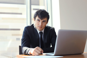 Young businessman working in the office with laptop.