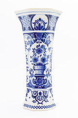 A tall ancient white ceramic flower vase painted with dark blue ornaments isolated on white background