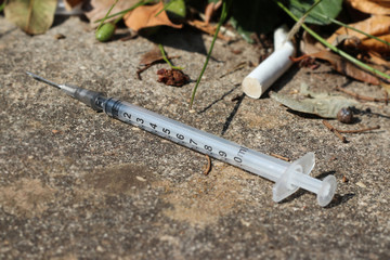 used and discarded syringe on the street