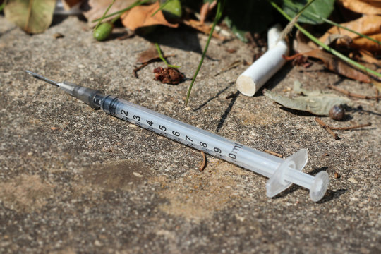 used and discarded syringe on the street