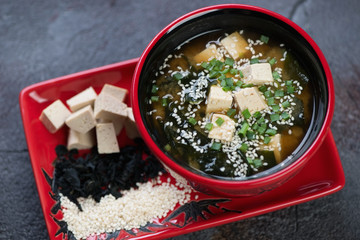 Closeup of miso soup with tofu, wakame seaweed and sesame seeds, elevated view