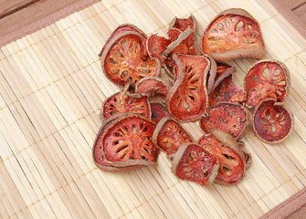 Pile sliced Bael dried on wood background.