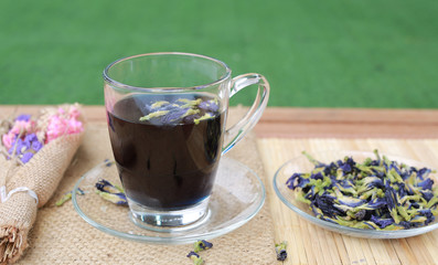 Juice of Butterfly pea in glass on wooden table. Herb drink with Dried Butterfly pea.