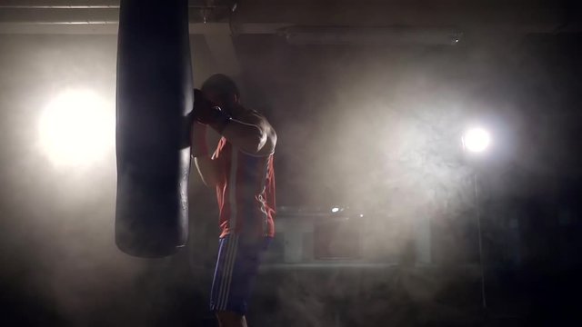 a young athlete boxing in boxing gloves with a sports pear in a modern fitness club