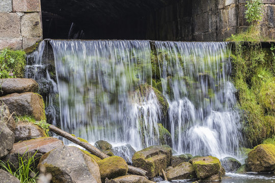 very steep waterfall flowing beneath the bridge © Normunds