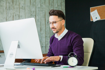 Handsome businessman office worker typing computer monitor