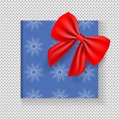 Blue Christmas gift box with red satin bow. Happy New Year and Merry Christmas congratulation card