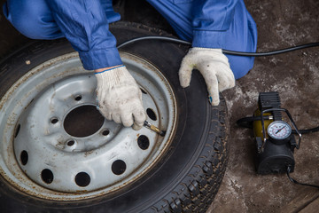 the mechanic pumps the car's wheel