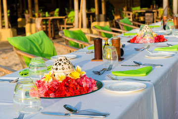 Table setting for wedding reception with red and yellow flowers