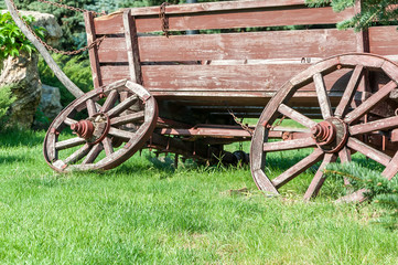 Fototapeta na wymiar An old cart for transportation on green grass close-up