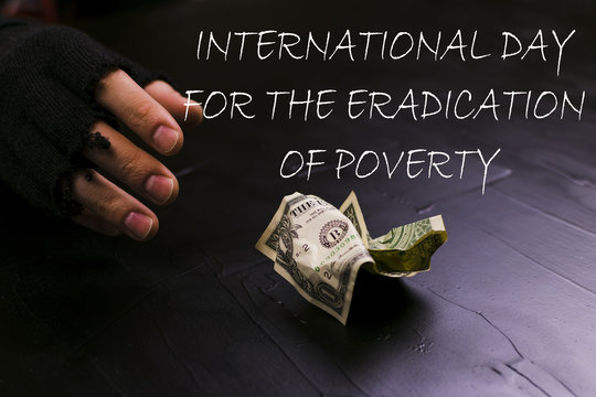 The man reaches for a dollar bill. Day for the eradication of poverty.